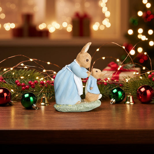 Decorative figurine of a couple embracing on a table with Christmas decorations and lights in the background.