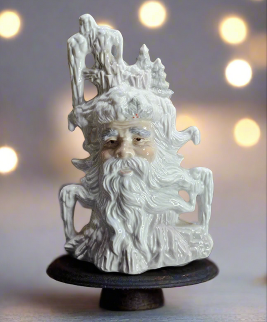Decorative figure of a bearded figure on a stand with a blurred light background