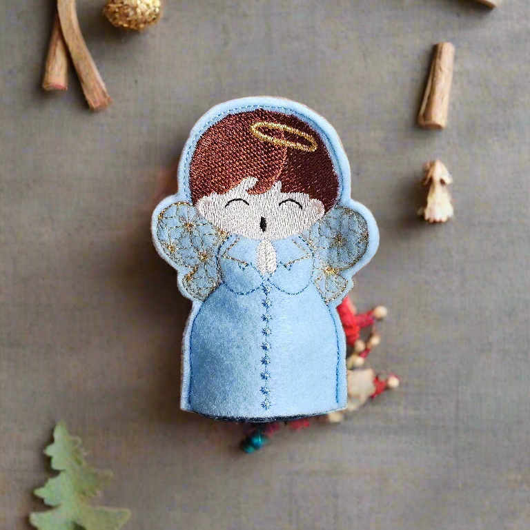 Embroidered angel patch on a textured surface with decorative elements.