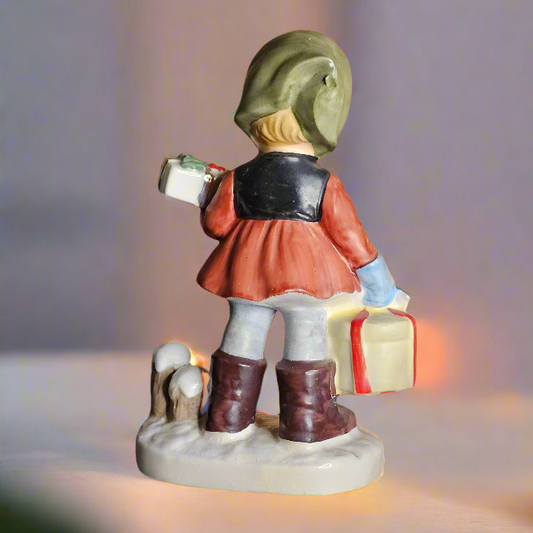 Figurine of a child holding a gift with a blurred warm light background